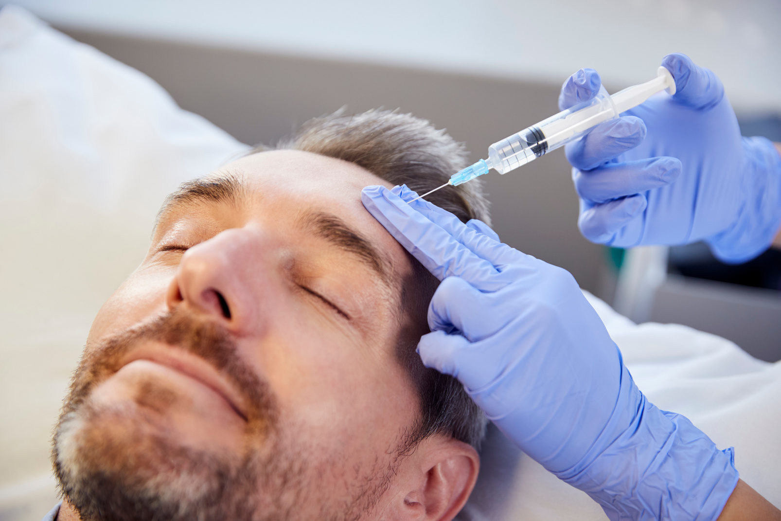 Female Beautician Giving Mature Male Patient Botox Injection in